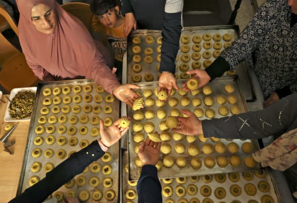 Palestinian women make traditional date and nuts filled cookies in preparation for the Eid al-Fitr holiday, in the West Bank city of Hebron, on April 28, 2022. Eid al-Fitr marks the end of Muslim's holy fasting month of Ramadan.