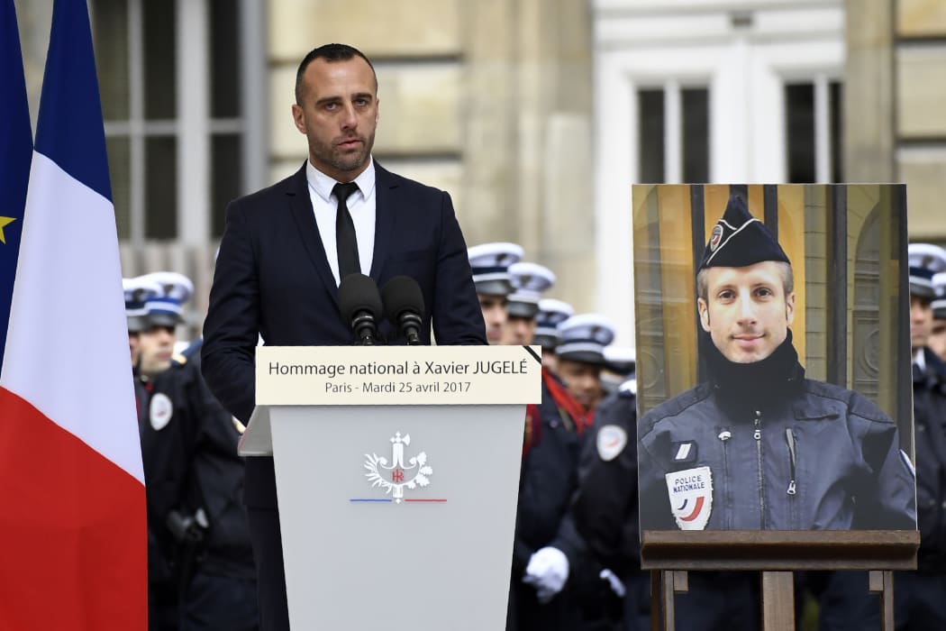 Etienne Cardiles gave a moving address at the ceremony of remembrance for his  partner, policeman Xavier Jugele, whose portrait is placed by his side.