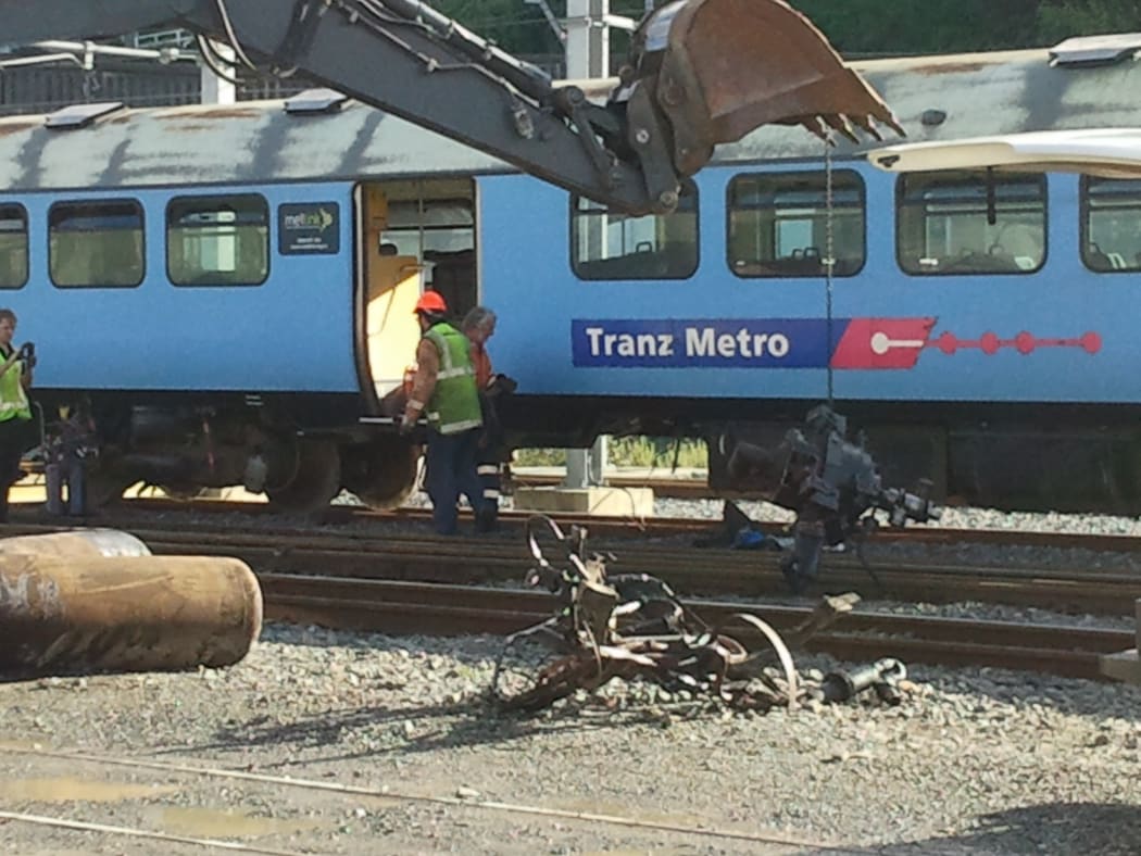 Mangled parts of the train are moved away for inspection.