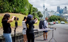 The film crew filming Kareem Adel Ismail leaving the Gladstone Tennis Club with Auckland cityscape in the background..