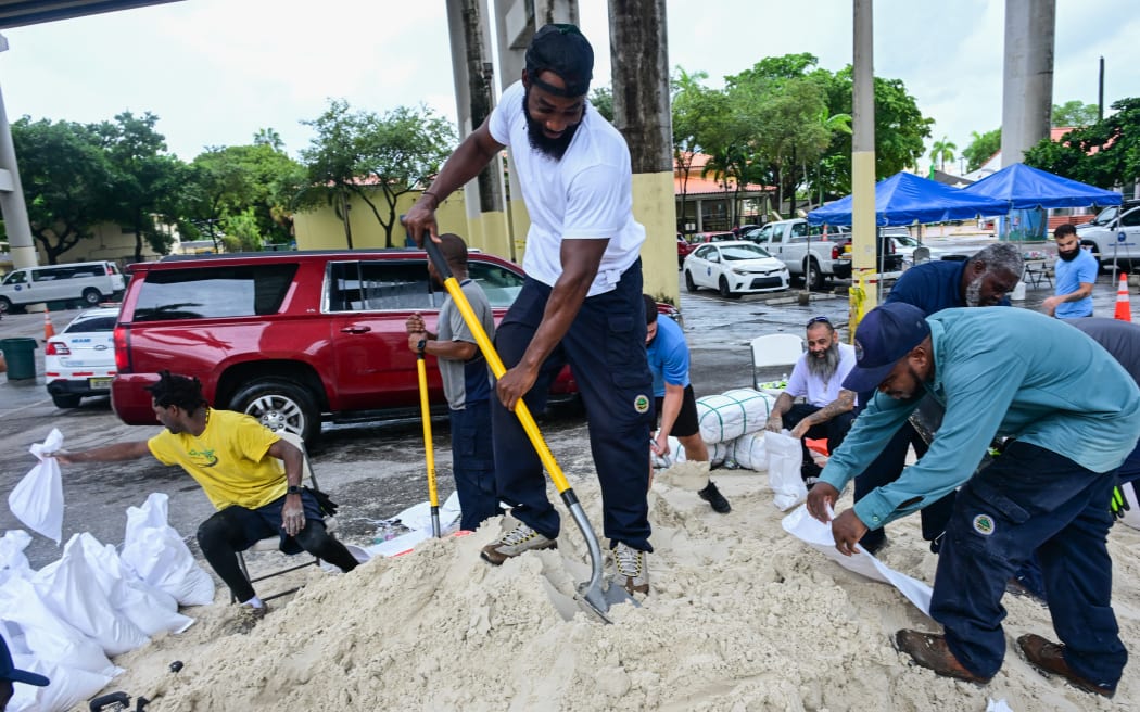 Volunteers from the city of Miami fill sandbags to help residents prepare for the arrival of Hurricane Milton in Miami, Florida on October 7, 2024. - Florida's governor has declared a state of emergency on Saturday as forecasters warned that Hurricane Milton is expected to make landfall later this week. (Photo by Giorgio VIERA / AFP)