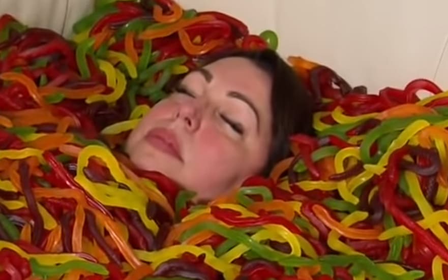 Kylie Lowe sumberged in jelly snake sweets for A Current Affair