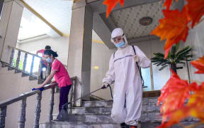 Staff members disinfecting a facility to prevent the spread of the Covid-19 coronavirus in a Pyongyang hotel on 2 July 2022.