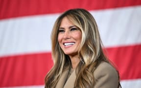 US First Lady Melania Trump smiles as US President Donald Trump (out of frame) speaks to members of the military and their families at Fort Bragg, North Carolina on February 13, 2026. Trump will meet on Friday with the special forces soldiers who captured Venezuelan leader Nicolas Maduro in a deadly raid in Caracas in January. (Photo by Mandel NGAN / AFP)