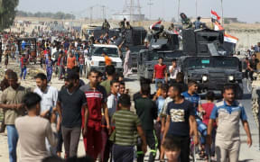 Civilians gather as Iraqi forces arrive in the southern outskirts of Kirkuk.