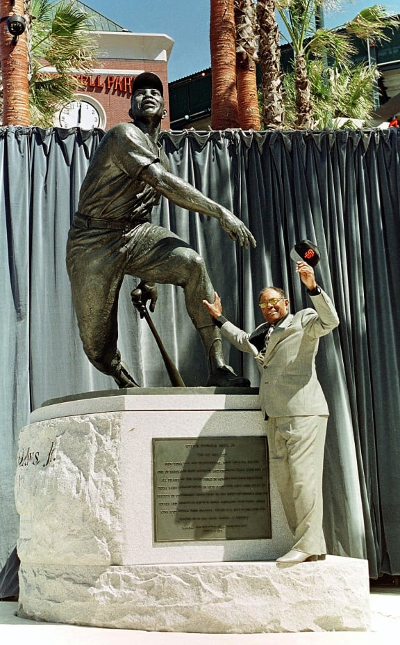 New York and San Francisco Giants Baseball Hall of Famer Willie Mays touches stands next to his statue its dedication by the San Francisco Giants at 24 Willie Mays Plaza in front of the Giants New home Pacific Bell Park 31 March, 2000, in San Francisco, California.
