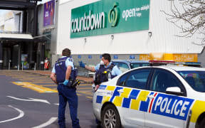 Police keep watch outside the Countdown supermarket at LynnMall.