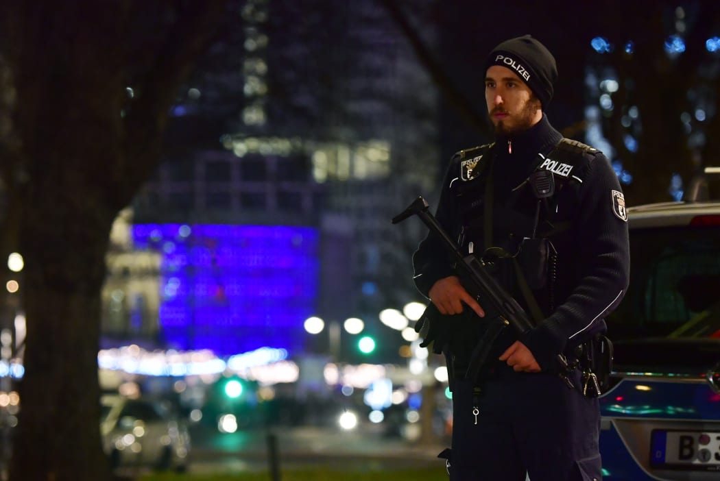 Police stand guard near the Berlin Christmas market after a truck ploughed into a crowd, killing nine.