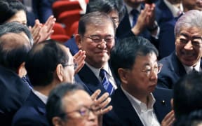 Shigeru Ishiba (centre), former secretary-general of LDP, smiles after winning Japan's Liberal Democratic Party presidential election by runoff vote in Tokyo on 27 September, 2024.