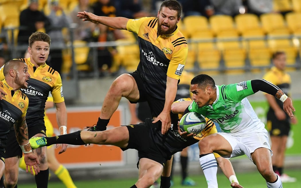 Highlander Aaron Smith is confronted by a leaping Dane Coles as TJ Perenara and Beauden Barrett look on.