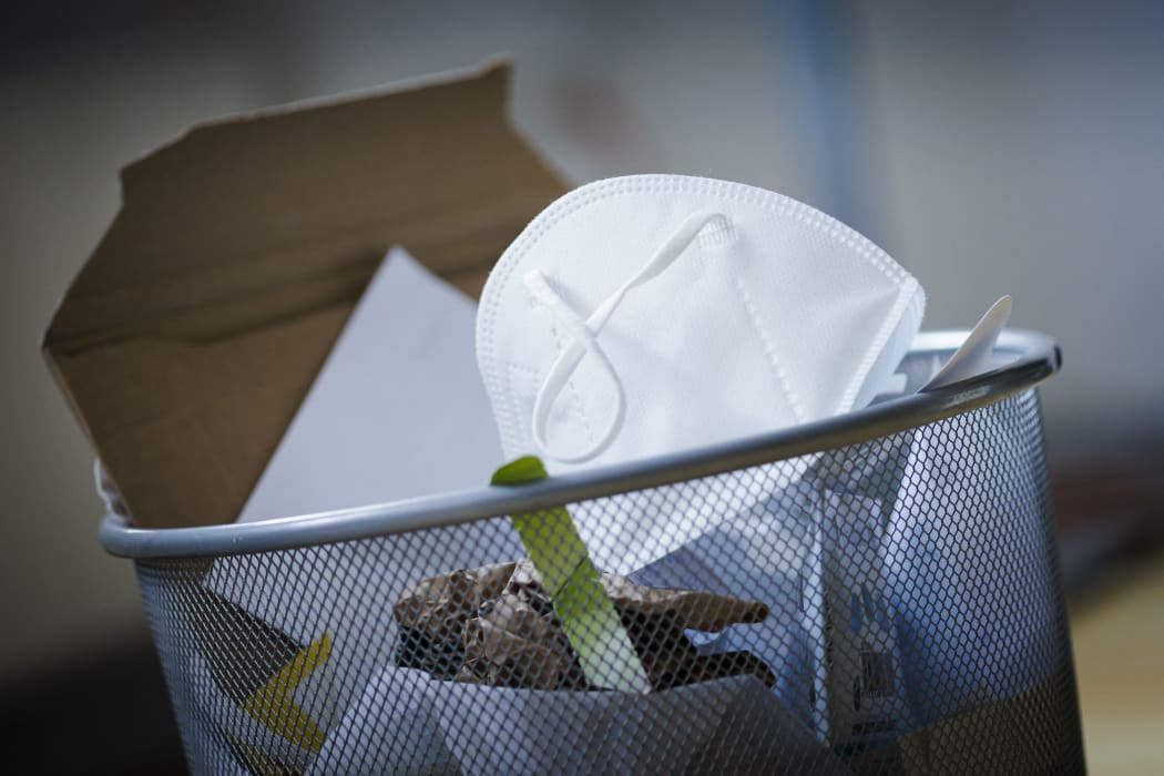 Symbolic photo on the topic ?Äô End of the mask requirement ?Äô. An FFP2 mask is in a garbage can. Berlin, March 10, 2022 (Photo by Thomas Trutschel / Photothek / dpa Picture-Alliance via AFP)