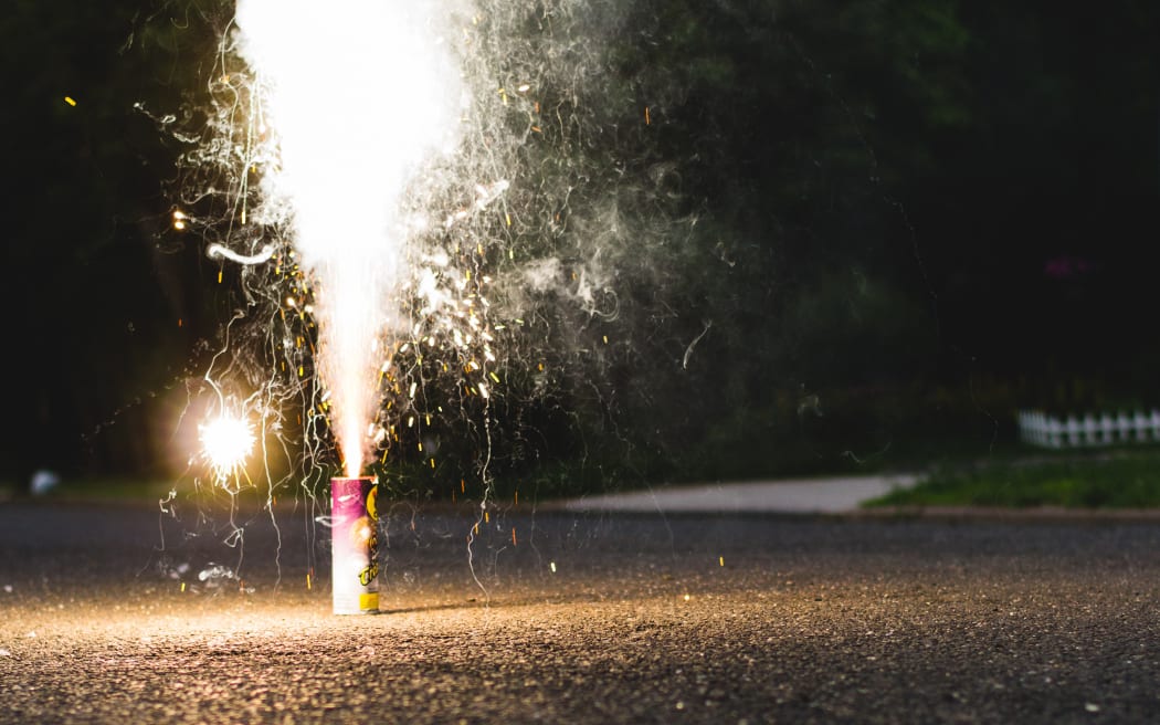 A small firework is set off on a street.