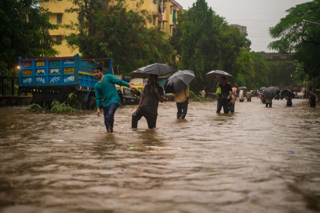 IA, Mumbai: People walk through water logging of streets in Mumbai, India on August 30, 2017 as the monsoon in the city worsened.