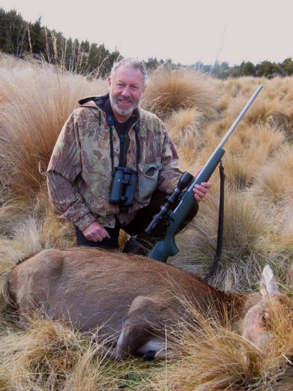Paul Clark outdoors with gun after shooting a deer