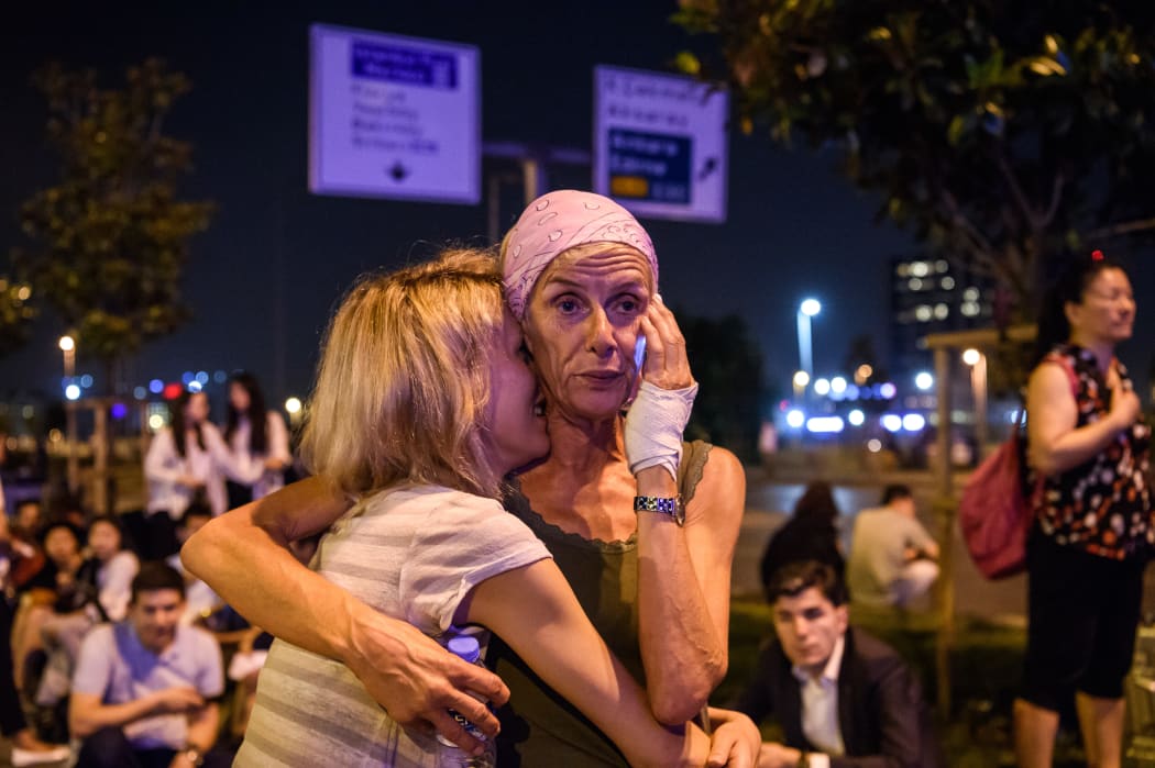 Passengers embrace outside Ataturk airport`s main entrance in Istanbul.