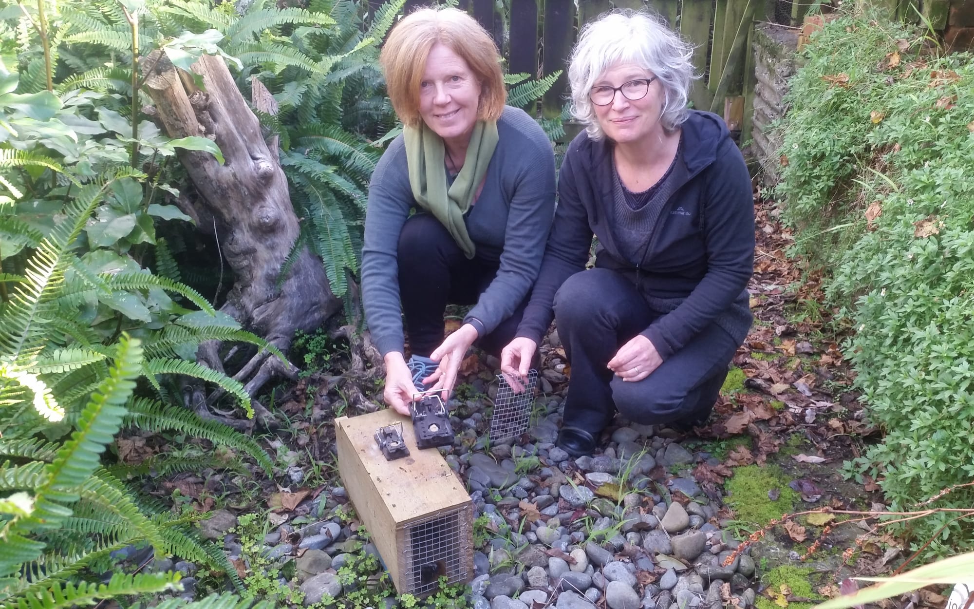 Linda Kerkmeester (left) and Heather Evans with with one of the traps they use to catch pests in their Plimmerton backyards