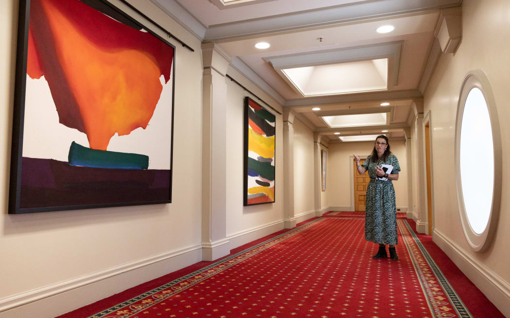 Parliamentary Curator Tasha Fernandez shows off two of Parliament's Gretchen Albrecht paintings.