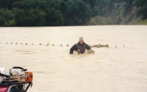 Mike Cranstone rescues sheep on his flooded farm in 2004.