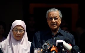Newly-elected Malaysian Prime Minister Mahathir Mohamad (R) addresses the media next to Wan Azizah, the wife of jailed former opposition leader and current Federal opposition leader Anwar Ibrahim