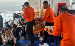 This handout photo from the Philippine Coast Guard (PCG) taken and received on January 26, 2026 shows coast guard crew attending to the survivors of the sunken M/V Trisha Kerstin 3 in waters off Basilan province. A ferry carrying 342 passengers sank on January 26 morning in the southern Philippines, leaving at least eight dead, a local mayor said. (Photo by Handout / Philippine Coast Guard (PCG) / AFP) / RESTRICTED TO EDITORIAL USE - MANDATORY CREDIT "AFP PHOTO /  PHILIPPINE COAST GUARD (PCG)" - HANDOUT - NO MARKETING NO ADVERTISING CAMPAIGNS - DISTRIBUTED AS A SERVICE TO CLIENTS