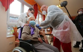 Edith Kwoizalla, 101 years old, receives the first vaccination against the novel coronavirus COVID-19 by Pfizer and BioNTech from Doctor  Bernhard Ellendt (R) in a senior care facility in Halberstadt (Seniorenzentrum Krueger), central northern Germany, on December 26, 2020.