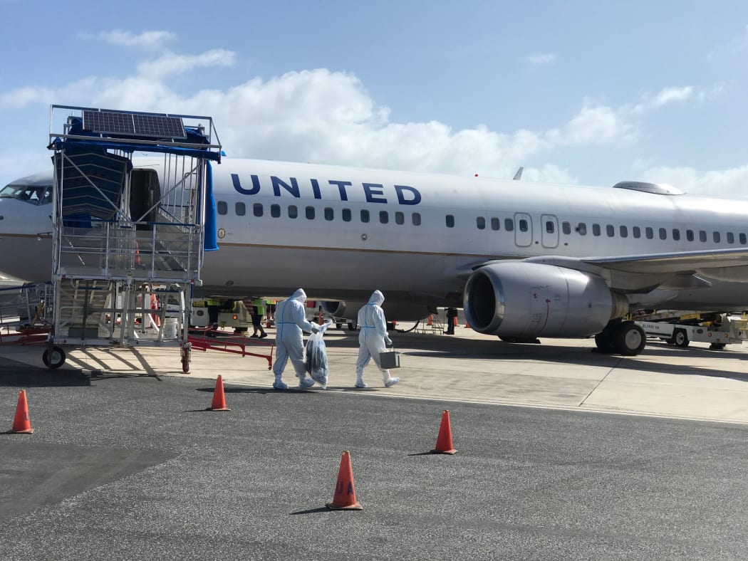 United Airlines workers in Majuro wore full-body PPE before going onto a United flight in May
