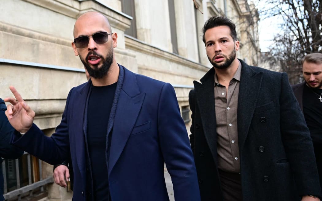 (FILES) Andrew Tate (L) and Tristan Tate (R) walk from the Bucharest's Court of Appeal after a hearing about their demand to be allowed to leave Romania as their mother allegedly suffered a heart attack, in Bucharest, on December 22, 2023. Controversial influencer Andrew Tate and his brother have been arrested in Romania over UK sex offence charges, police said on March 12, 2024. Police said in a statement it executed "two European arrest warrants issued by the UK judicial authorities for the committing of sexual offences, of exploitation of persons on the territory of the UK". (Photo by Daniel MIHAILESCU / AFP)