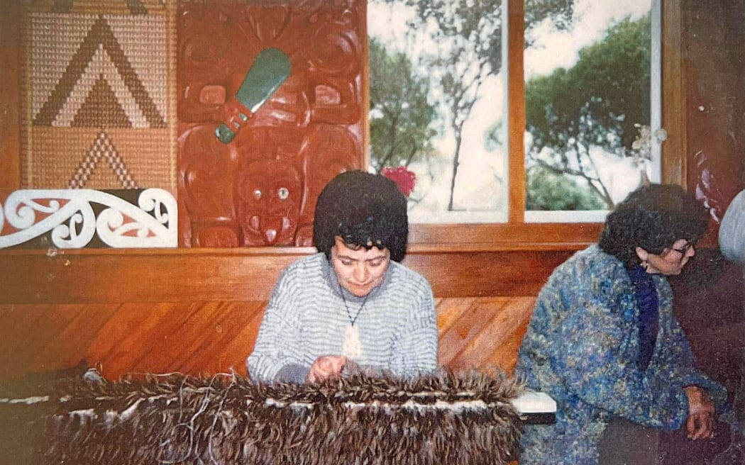 One of Tahu’s earliest memories was of a nanny coming to visit her family home as a child, sitting amongst the harakeke and weaving kete. Tahu later picked up the skill through making muka for her brothers’ eeling excursions. Here she is pictured in younger days, deep in her craft.