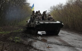 Ukrainian soldiers stand on an armoured personnel carrier (APC), not far from the front-line with Russian troops, in Izyum district, Kharkiv region.