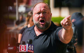 WATERBURY, CONNECTICUT - SEPTEMBER 21: InfoWars founder Alex Jones speaks to the media outside Waterbury Superior Court during his trial on September 21, 2022 in Waterbury, Connecticut. Jones is being sued by several victims' families for causing emotional and psychological harm after they lost their children in the Sandy Hook massacre. A Texas jury last month ordered Jones to pay $49.3 million to the parents of 6-year-old Jesse Lewis, one of 26 students and teachers killed in the shooting in Newtown, Connecticut.   Joe Buglewicz/Getty Images/AFP (Photo by Joe Buglewicz / GETTY IMAGES NORTH AMERICA / Getty Images via AFP)