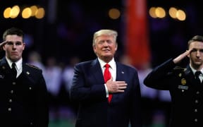 US President Donald Trump on field during the national anthem prior to the CFP National Championship presented by AT&T between the Georgia Bulldogs and the Alabama Crimson Tide at Mercedes-Benz Stadium on January 8, 2018 in Atlanta, Georgia.