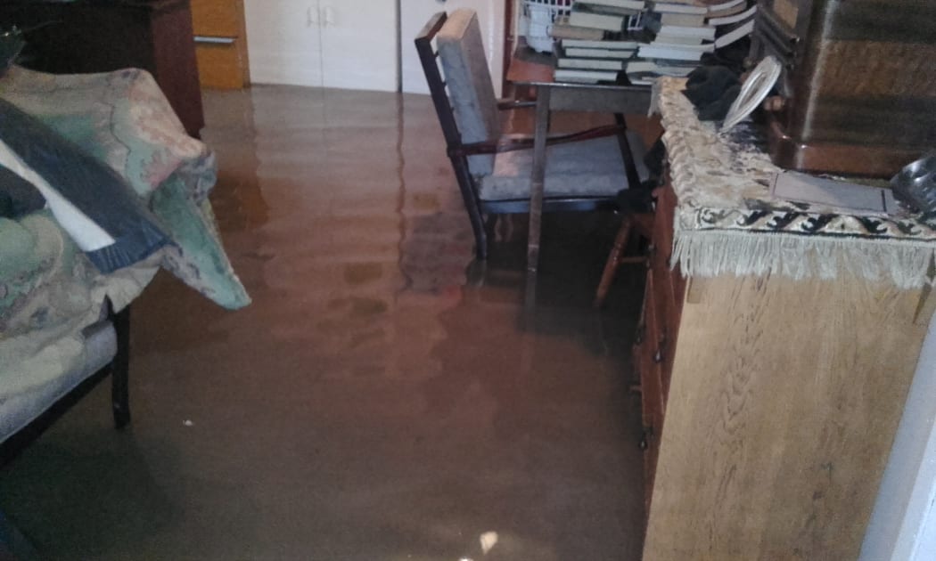 Floodwaters in the Lamberts' house have forced them to stack furniture and valuables to keep them dry.