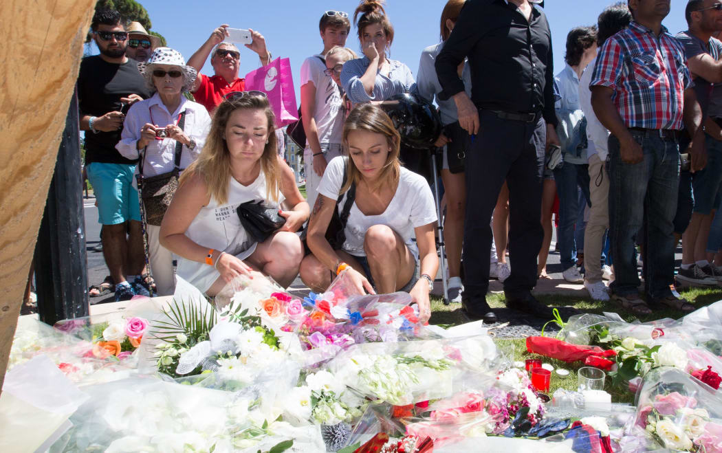 People offer flowers to the victims near the site of the terrorist attack in Nice, France,