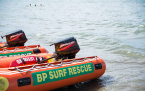 A surf rescue boat sitting on the beach.