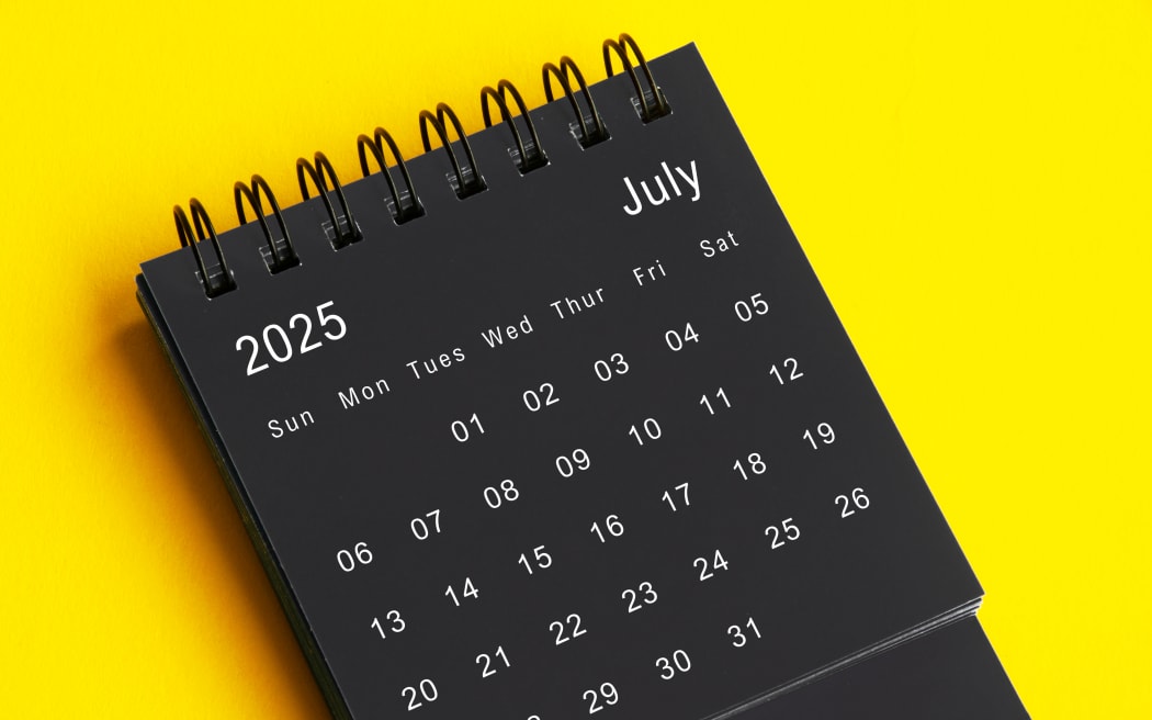 July 2025 black and white desk calendar on yellow cover background. Calendar concept.