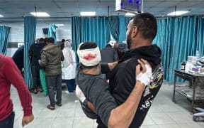 An injured Palestinian man is transported to the emergency ward of the Kamal Adwan Hospital, following an Israeli strike in Beit Lahia in the northern Gaza Strip on 21 November 2024.