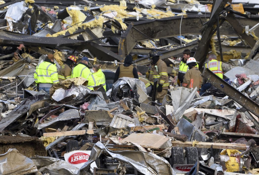 Emergency workers search what is left of the Mayfield Consumer Products Candle Factory after it was destroyed by a tornado in Mayfield, Kentucky, on 11 December 2021.