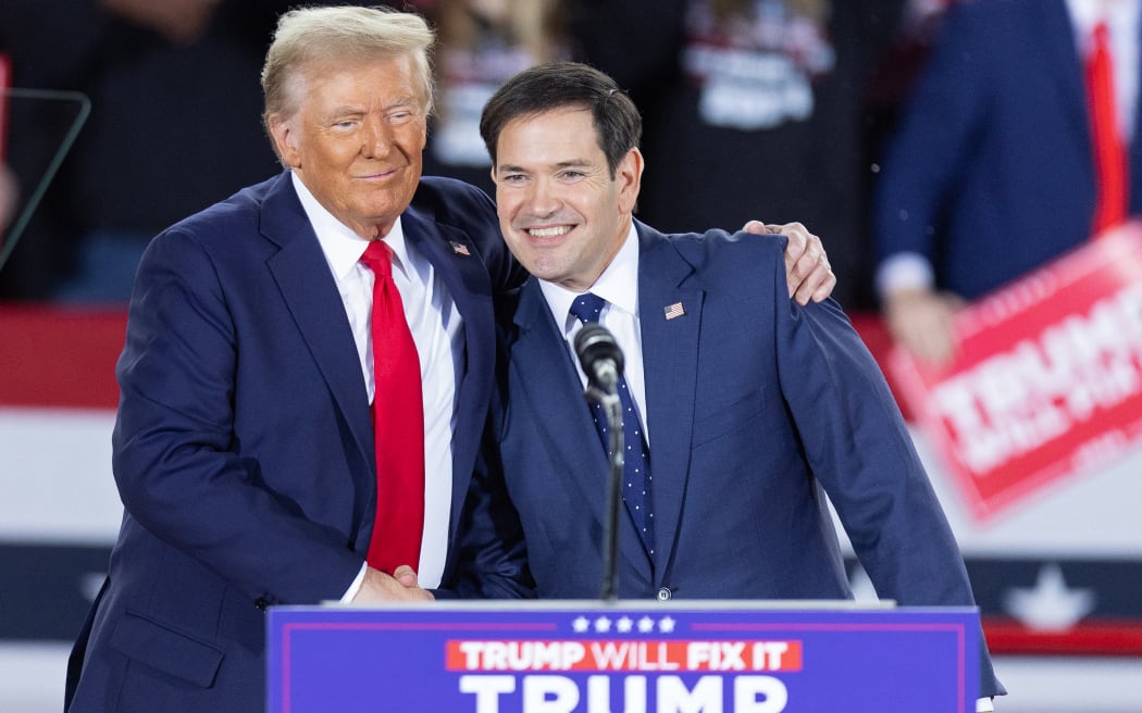 (FILES) Former US President and Republican presidential candidate Donald Trump greets Senator Marco Rubio, Republican of Florida, during a campaign rally at the J.S. Dorton Arena in Raleigh, North Carolina, on November 4, 2024. - President-elect Trump is expected to name Rubio as secretary of state, The New York Times reported late on November 11, 2024. It quoted three people as saying that the decision is not final, but that Trump appears to have settled on Rubio, a loyalist whom Trump passed over as his vice presidential running mate. (Photo by Ryan M. Kelly / AFP)