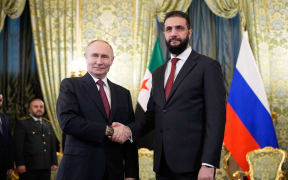 Russian President Vladimir Putin and Syrian interim president Ahmed al-Sharaa shake hands during their meeting at the Grand Kremlin Palace in Moscow on October 15, 2025. (Photo by Alexander Zemlianichenko / POOL / AFP)