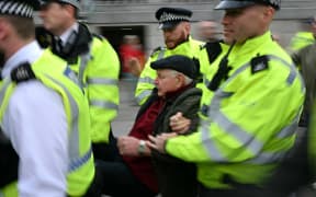 A protester is taken away by police officers at a "Lift The Ban" demonstration in support of the proscribed group Palestine Action, calling for the recently imposed ban to be lifted, in Trafalgar Square, central London, on October 4, 2025. (Photo by JUSTIN TALLIS / AFP)