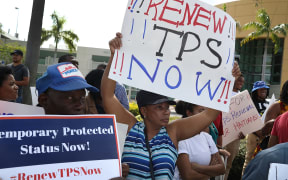 People protest the possibility that the Trump administration may overturn the Temporary Protected Status for Haitians in front of the U.S. Citizenship and Immigration Services office on May 13, 2017 in Miami, Florida.