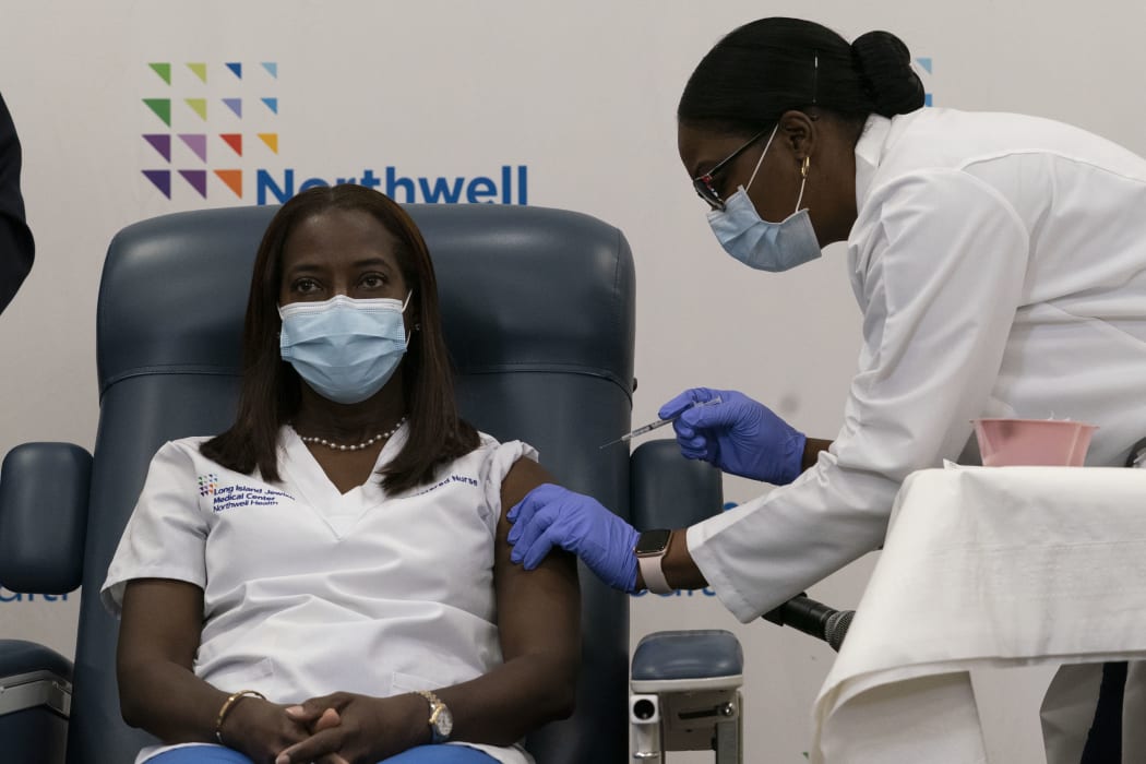 Sandra Lindsay, left, a nurse at Long Island Jewish Medical Center, is inoculated with the Covid-19 vaccine by Dr. Michelle Chester, December 14, 2020 in the Queens borough of New York City.