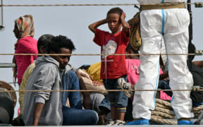 Migrants disembark from an Italian military ship at the port of Augusta, on the eastern coast of Sicily, on 21 May 2015.