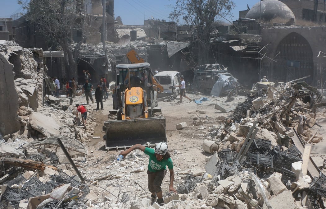 Syrians attend a rescue operation after the Assad Regime forces carried out an airstrike on a market in Aleppo, Syria on July 11, 2016.