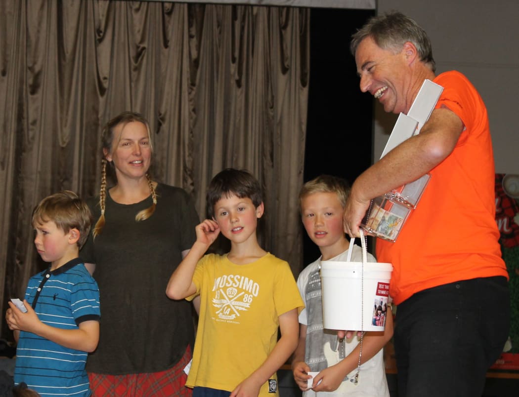 A photo of the event organiser, Jenny Cunningham, (second from left) handing the $2600 raised over to World Vision NZ CEO, Chris Clarke