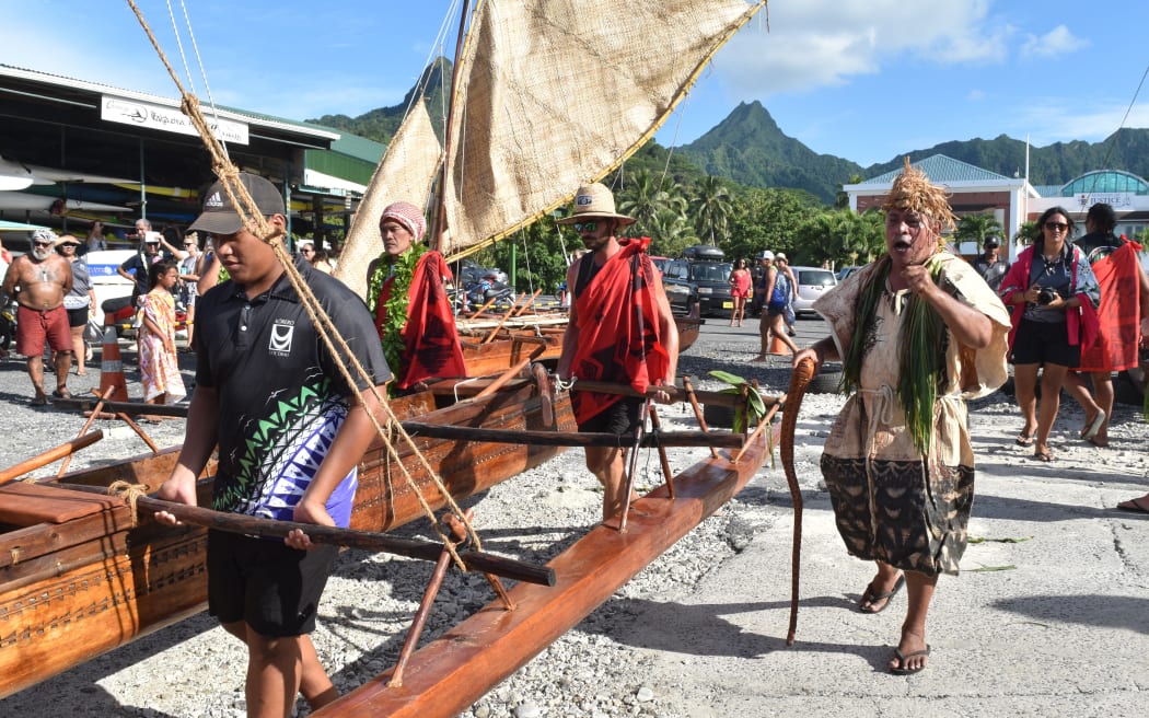 Vaka builders walk down the canoes that they spent four months building into the ocean.