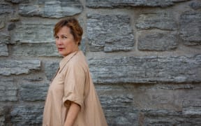 American singer-songwriter Iris DeMent against a rock wall