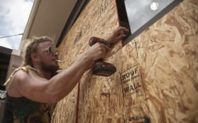 Matt Harrington boards up a Vans shoe store near the French Quarter in New Orleans as tropical storm Barry approaches.