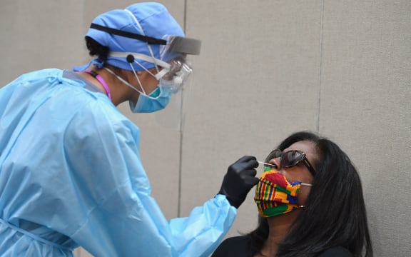 A healthcare worker takes a nasal swab sample from a resident to test for COVID-19 at The Abyssinian Baptist Church in the Harlem neighborhood of New York City on May 13, 2020.