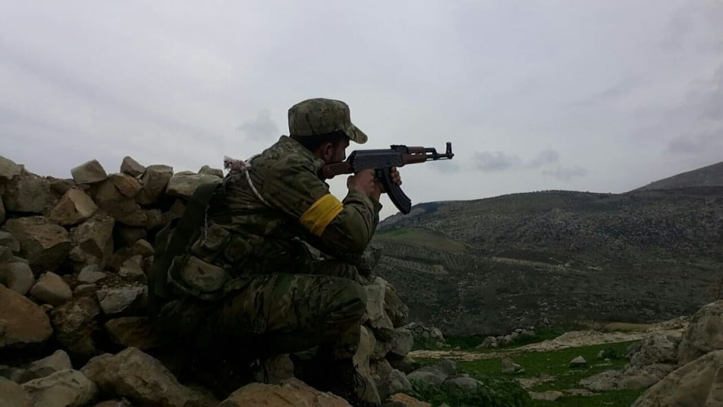 A Free Syrian Army (FSA) member backed by Turkish military at a village in Afrin